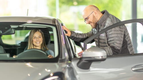 Un employé Steveny et une dame au volant d'un voiture discutent