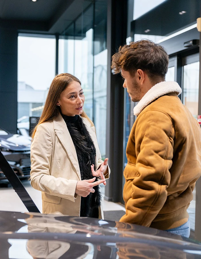 Femme qui donne des informations sur la prochaine voiture du client