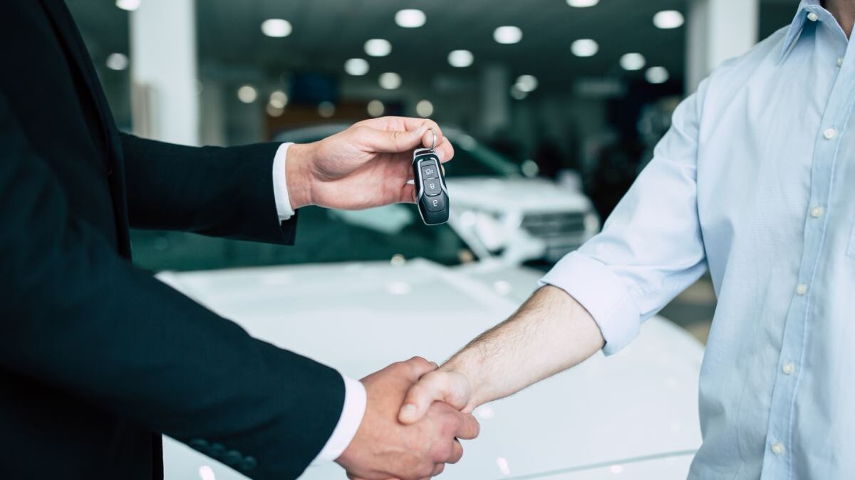 Homme qui achète une voiture et reçoit les clés